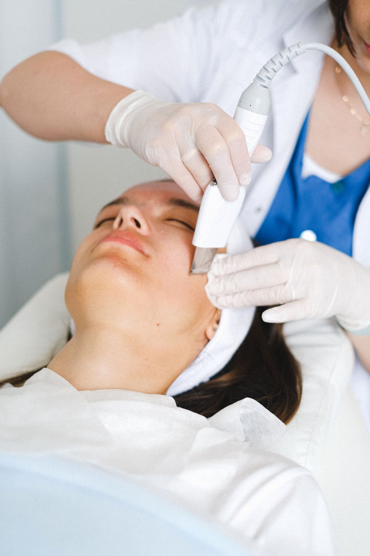 Procedimiento de limpieza facial con equipo ultrasónico en box clínico