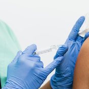 Enfermera aplicando una inyección intramuscular en el brazo
